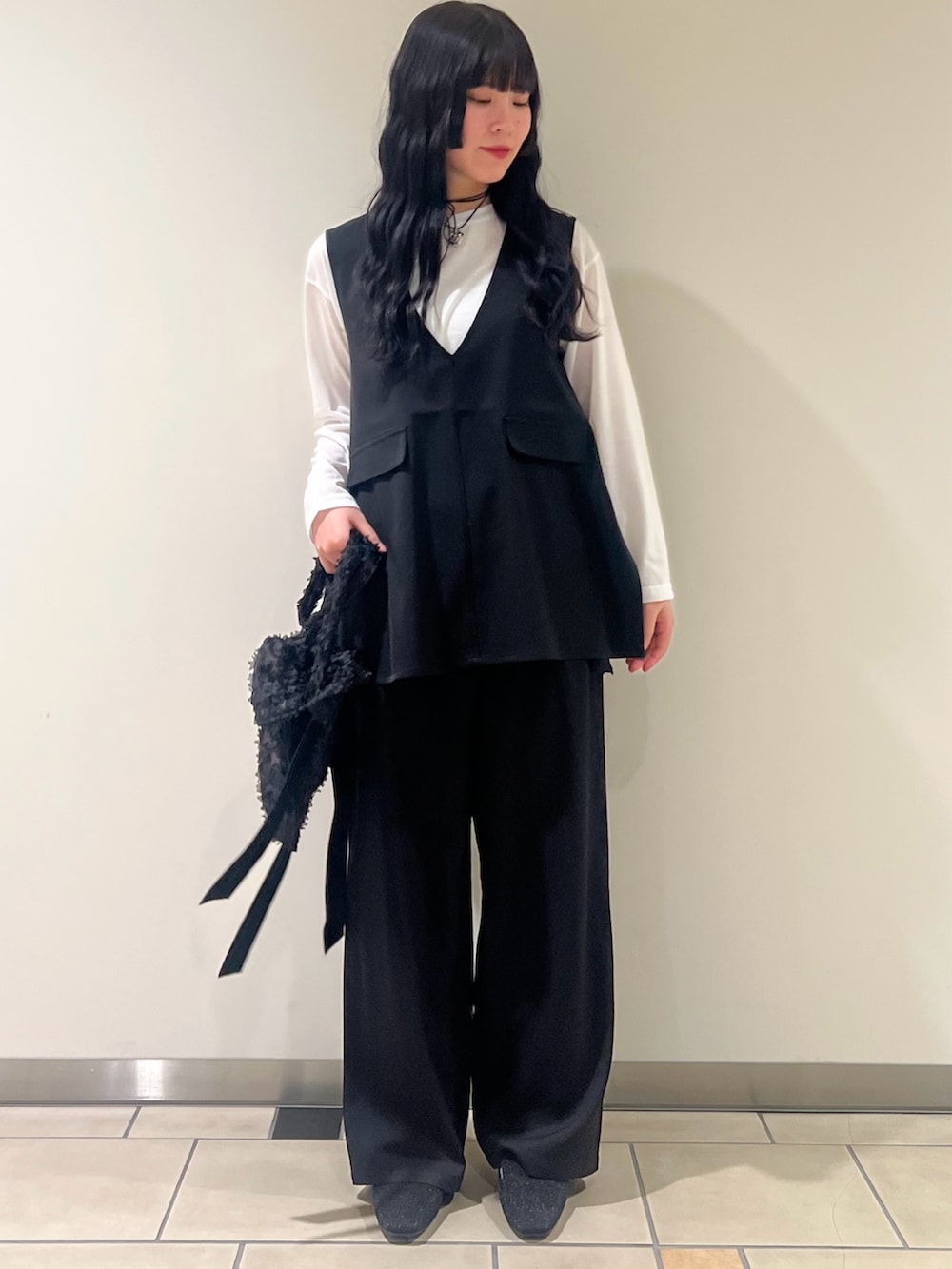 ブラック系のセットアップ、ブラック系のローファー、ブラック系のネックレスを着用したレディースの春コーディネートの2枚目の写真