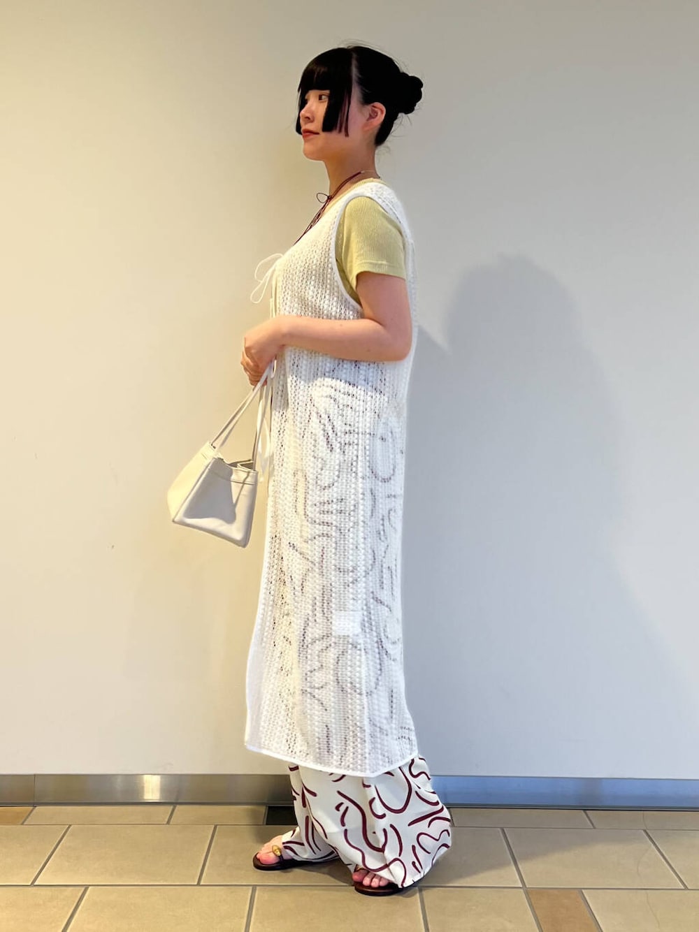 ブラウン系のサンダル、レッド系のその他パンツ、ホワイト系のハンドバッグを着用したレディースの夏コーディネートの2枚目の写真