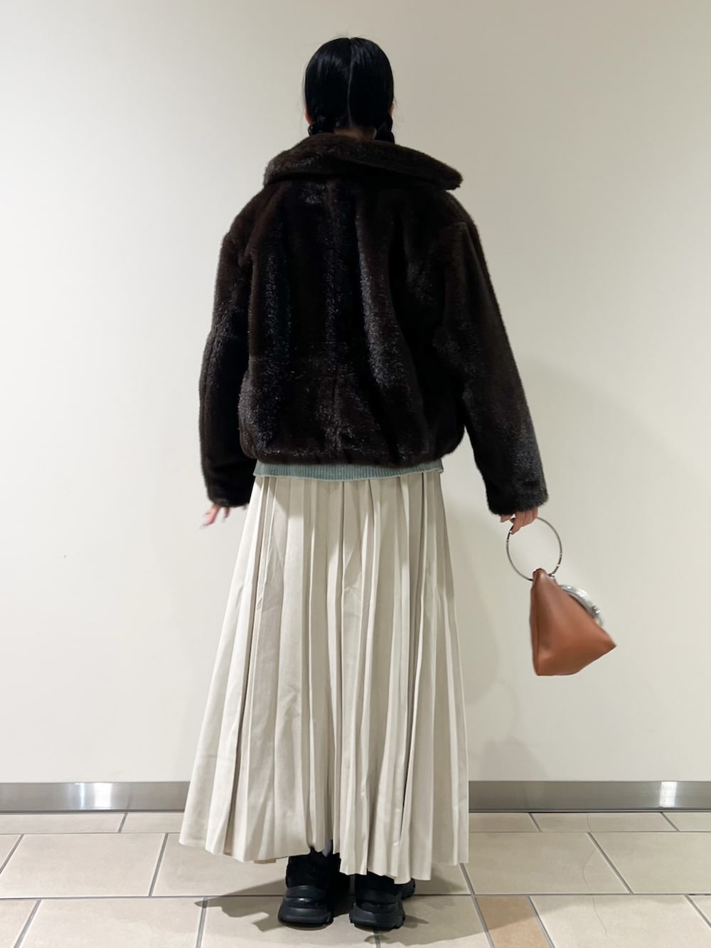 ブラウン系のその他アウター、グリーン系のニット/セーター、ベージュ系のスカートを着用したレディースの冬コーディネートの3枚目の写真