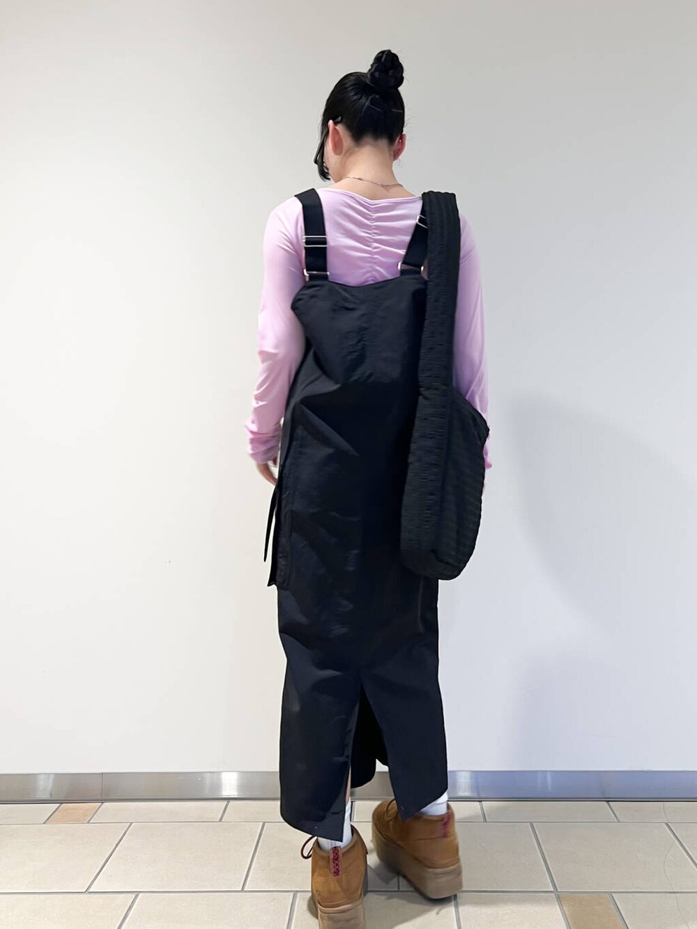 ブラック系のショルダーバッグ、ピンク系のTシャツ/カットソー、ブラック系のワンピースを着用したレディースの春コーディネートの3枚目の写真