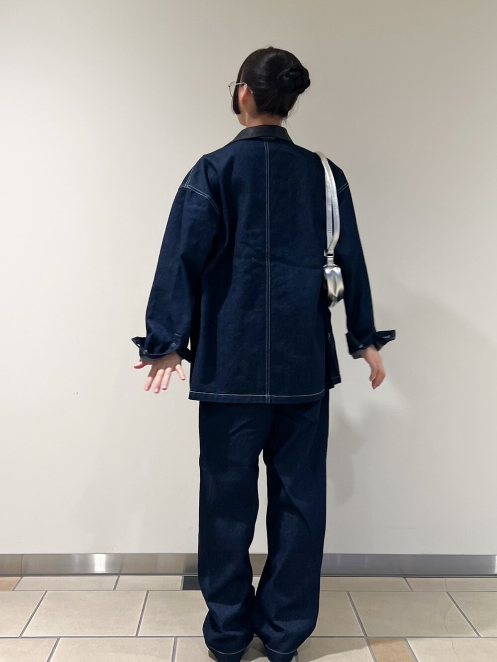 グリーン系のタンクトップ、シルバー系のショルダーバッグ、シルバー系のメガネを着用したレディースの秋コーディネートの3枚目の写真