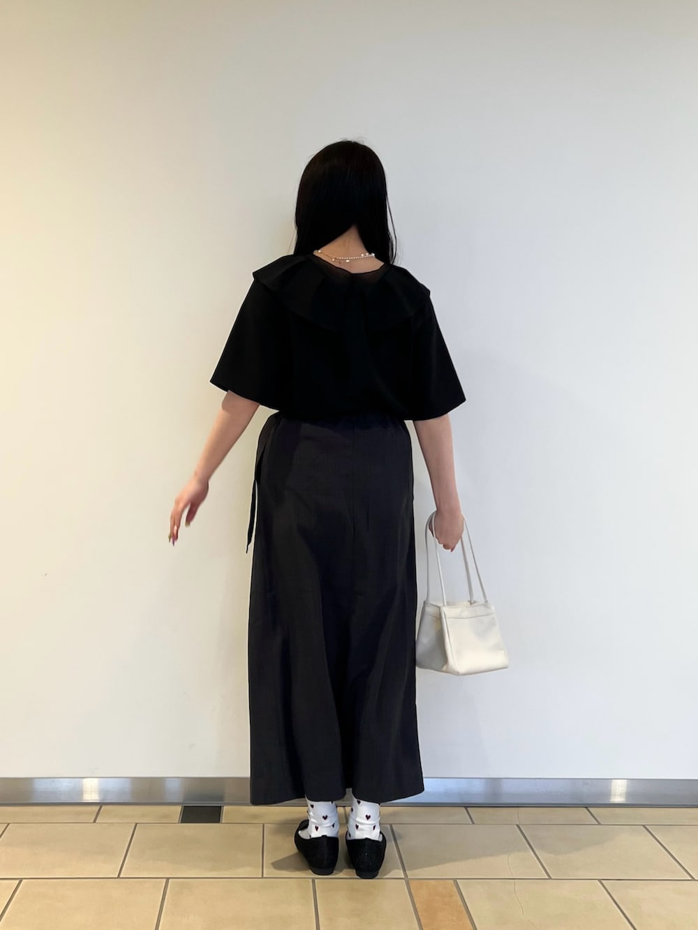 ブラック系のシャツ/ブラウス、グレー系のスカート、ブラック系のローファーを着用したレディースの春コーディネートの2枚目の写真