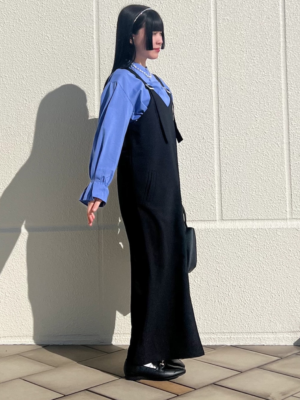 ブラック系のトートバッグ、ブラック系のワンピース、ブルー系のシャツ/ブラウスを着用したレディースの冬コーディネートの3枚目の写真