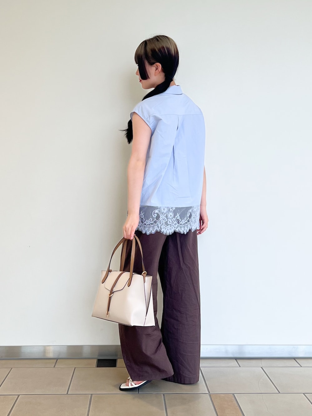 ブルー系のシャツ/ブラウス、ブラウン系のその他パンツ、ベージュ系のトートバッグを着用したレディースの夏コーディネートの3枚目の写真