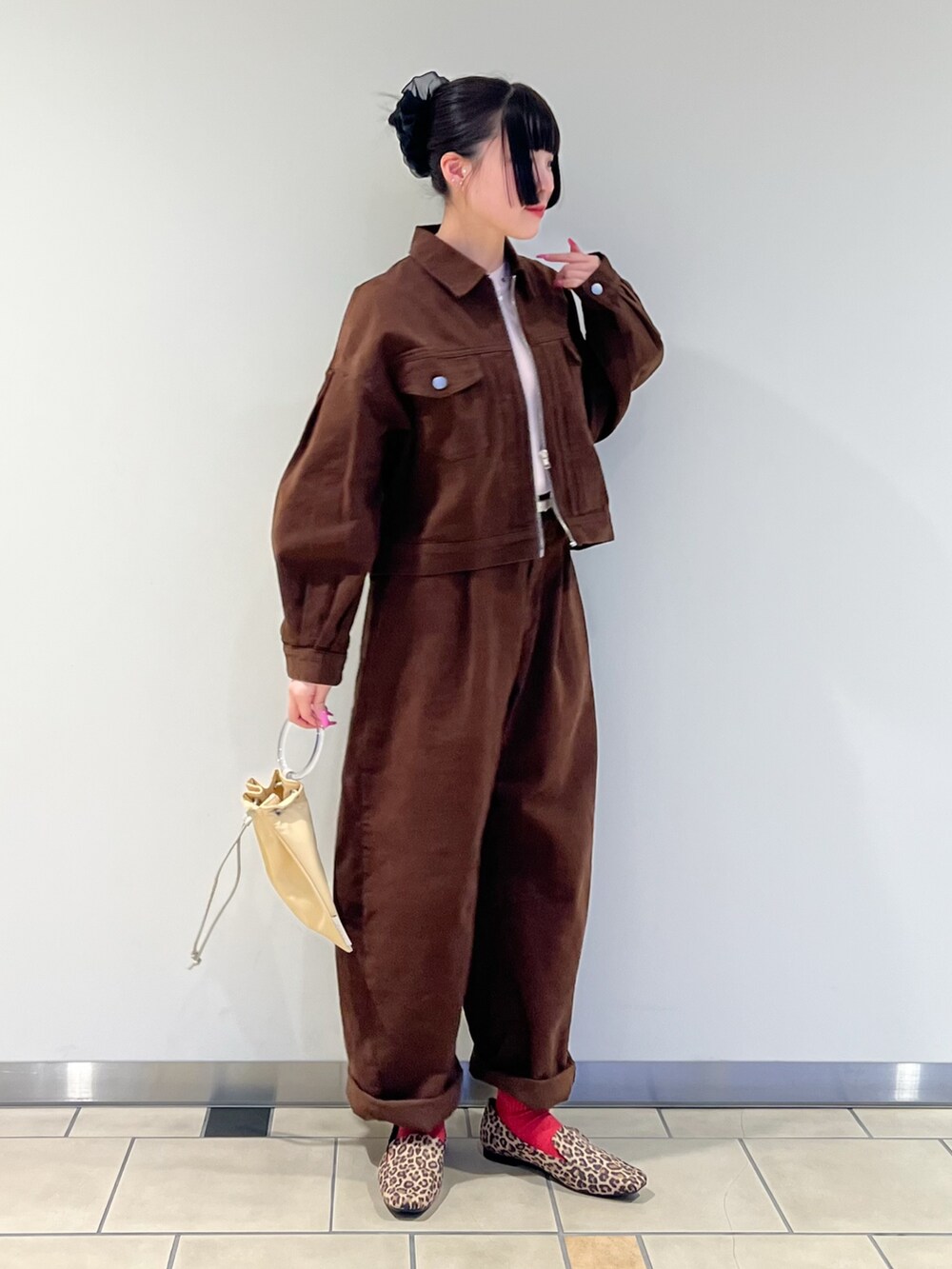 ピンク系のニット/セーター、ブラウン系のブルゾン、イエロー系のショルダーバッグを着用したレディースの冬コーディネートの2枚目の写真