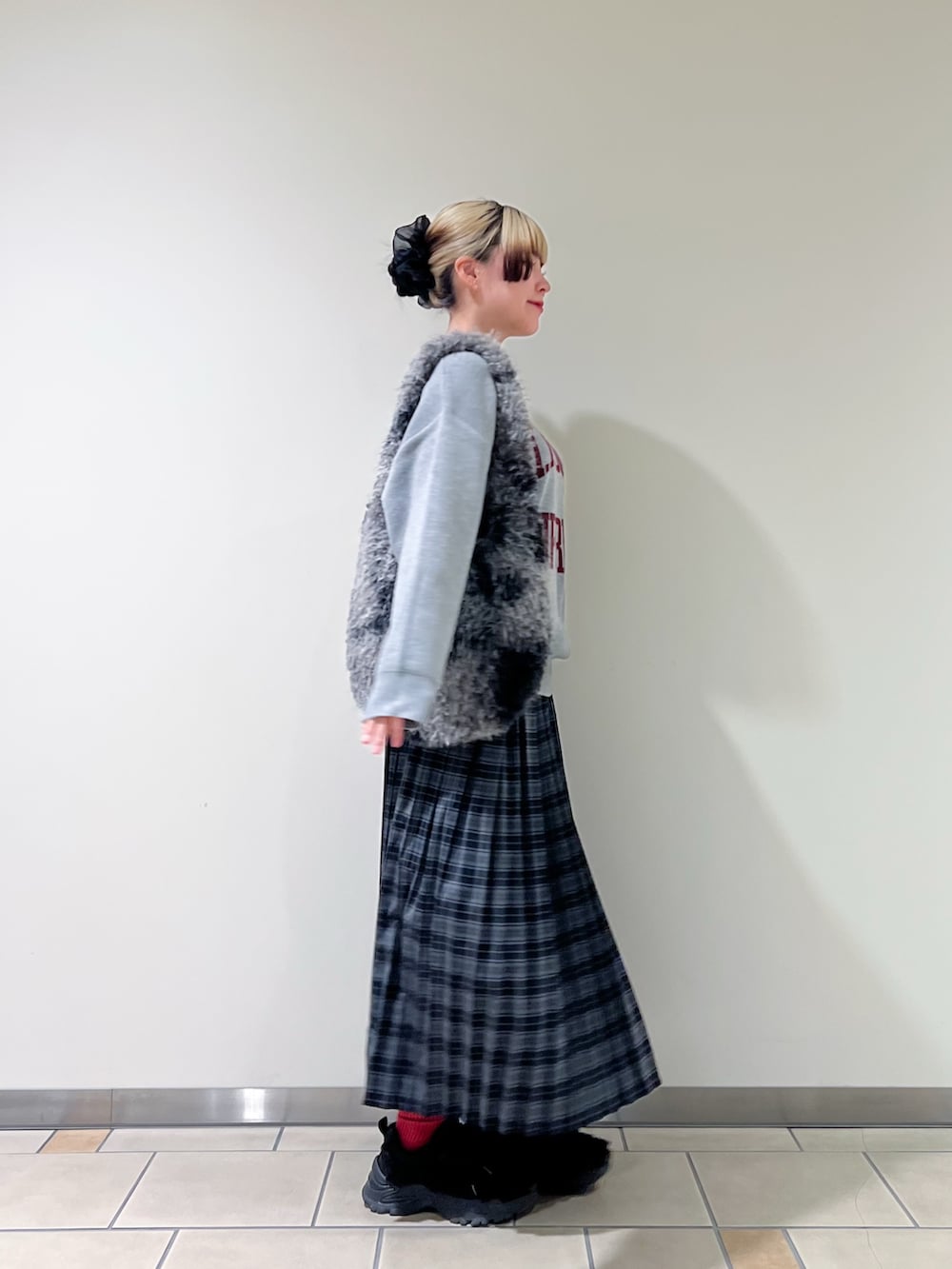 ブルー系のスカート、グレー系のトートバッグを着用したレディースの秋コーディネートの2枚目の写真