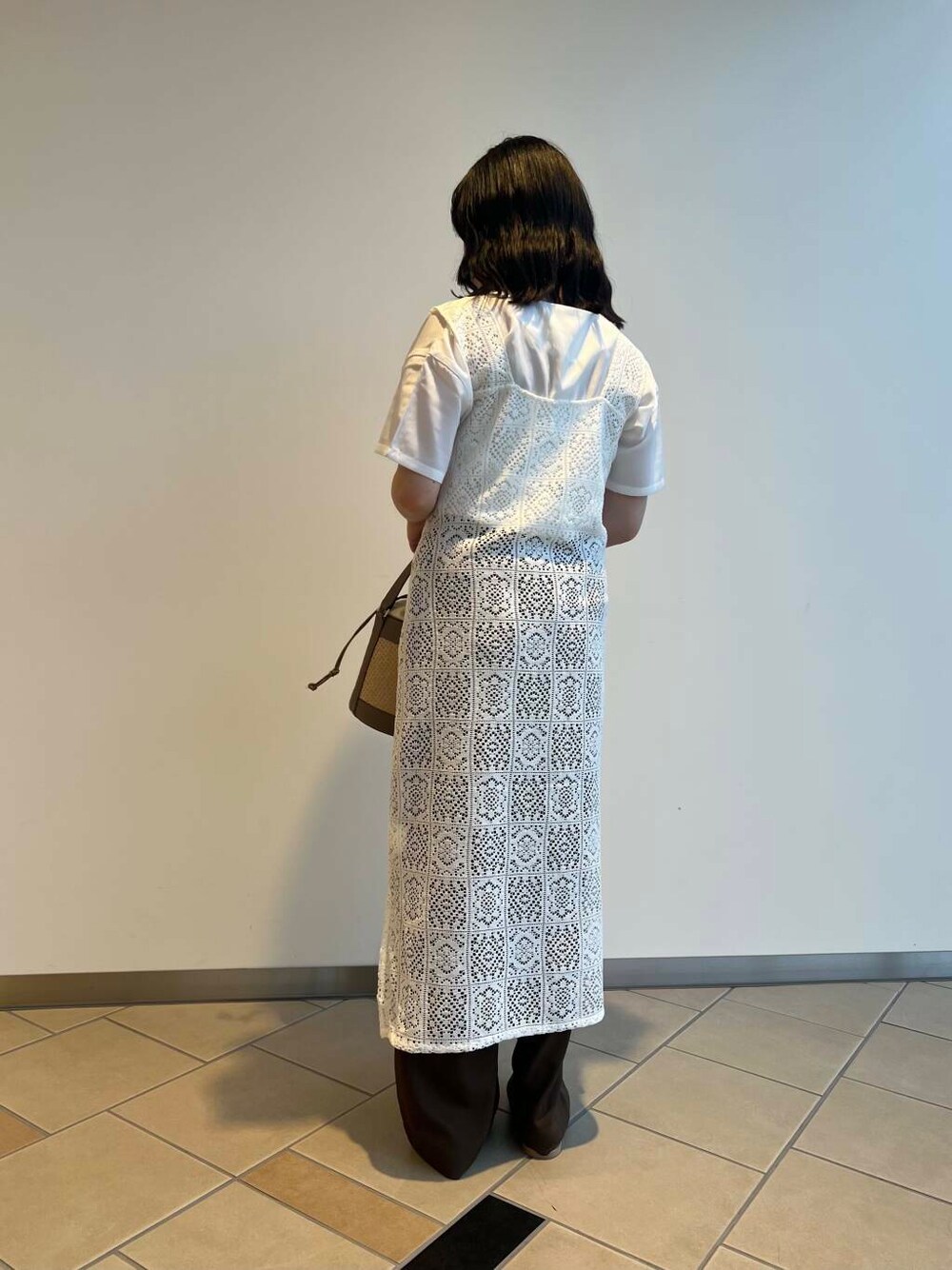 グレー系のショルダーバッグ、ベージュ系のサンダル、ホワイト系のTシャツ/カットソーを着用したレディースの夏コーディネートの4枚目の写真