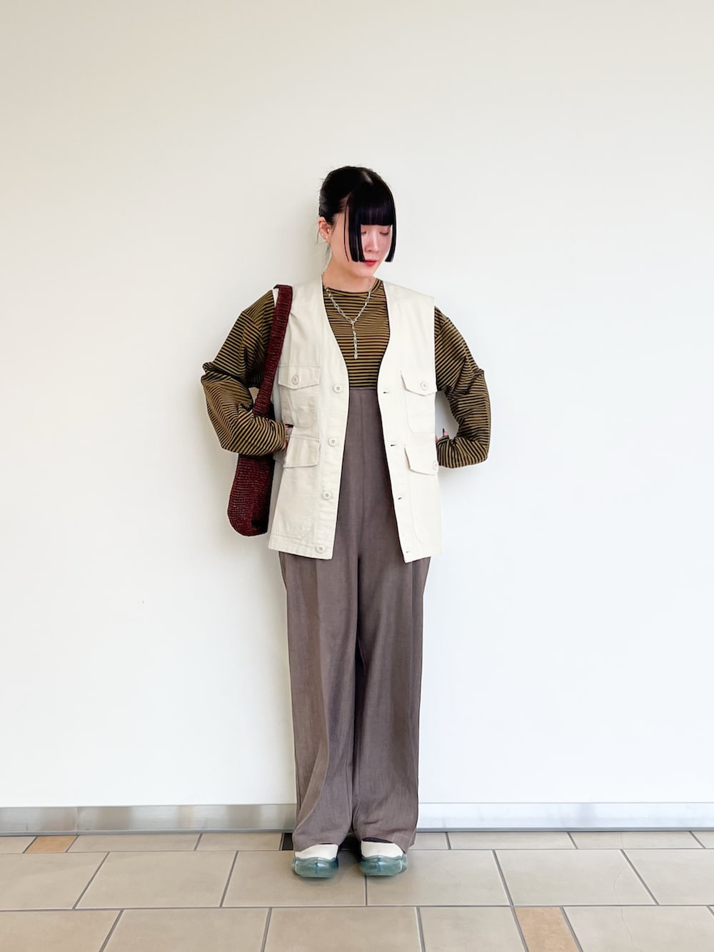 ブラウン系のTシャツ/カットソー、ホワイト系のベスト、ブラウン系のその他パンツを着用したレディースの春コーディネートの2枚目の写真