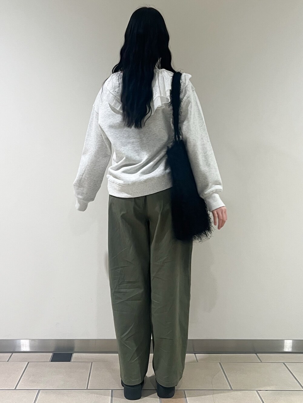 ブラック系のトートバッグ、グリーン系のその他パンツ、ベージュ系のスウェットを着用したレディースの冬コーディネートの2枚目の写真