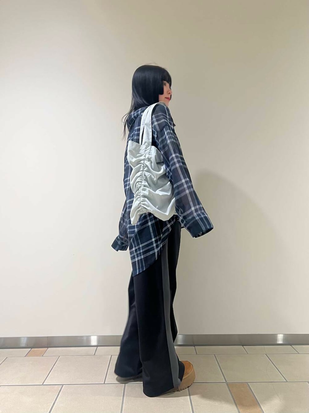 ブラック系のその他パンツ、グレー系のトートバッグ、ブルー系のシャツ/ブラウスを着用したレディースの春コーディネートの3枚目の写真