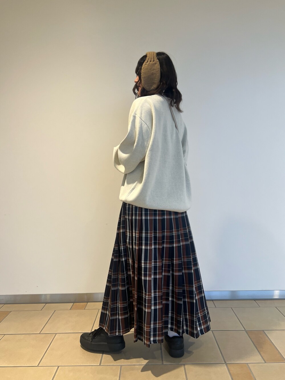 ベージュ系のショルダーバッグ、ホワイト系のニット/セーター、ブルー系のスカートを着用したレディースの秋コーディネートの3枚目の写真