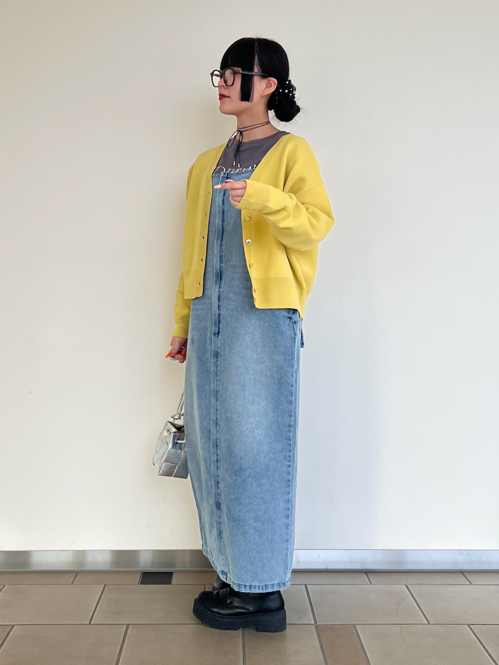 グレー系のTシャツ/カットソー、イエロー系のニット/セーター、ブルー系のワンピースを着用したレディースの冬コーディネートの2枚目の写真