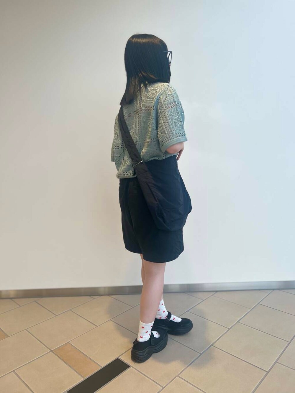 ブラック系のショルダーバッグ、グリーン系のニット/セーター、ブラック系のその他パンツを着用したレディースの夏コーディネートの2枚目の写真