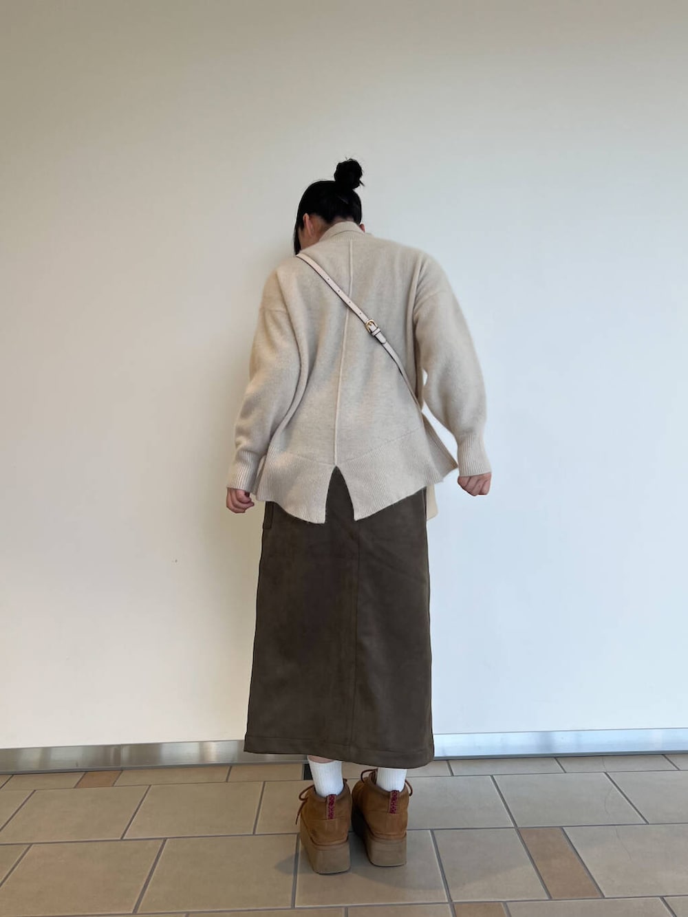 ホワイト系のショルダーバッグ、グリーン系のスカート、ホワイト系のニット/セーターを着用したレディースの秋コーディネートの2枚目の写真