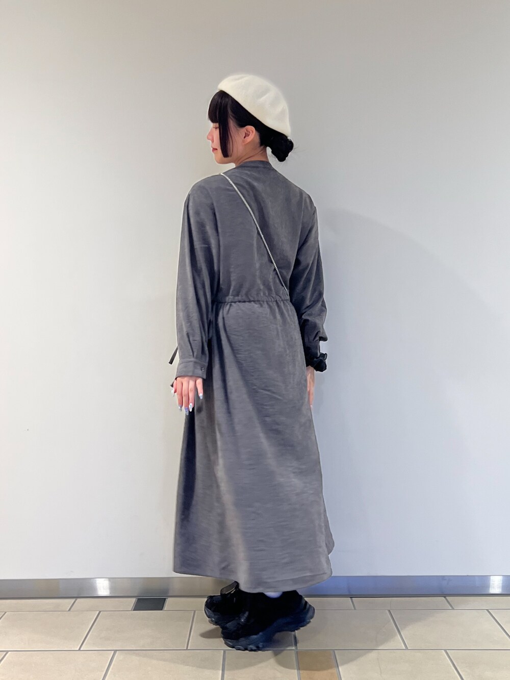 グレー系のワンピース、グリーン系のショルダーバッグを着用したレディースの秋コーディネートの2枚目の写真