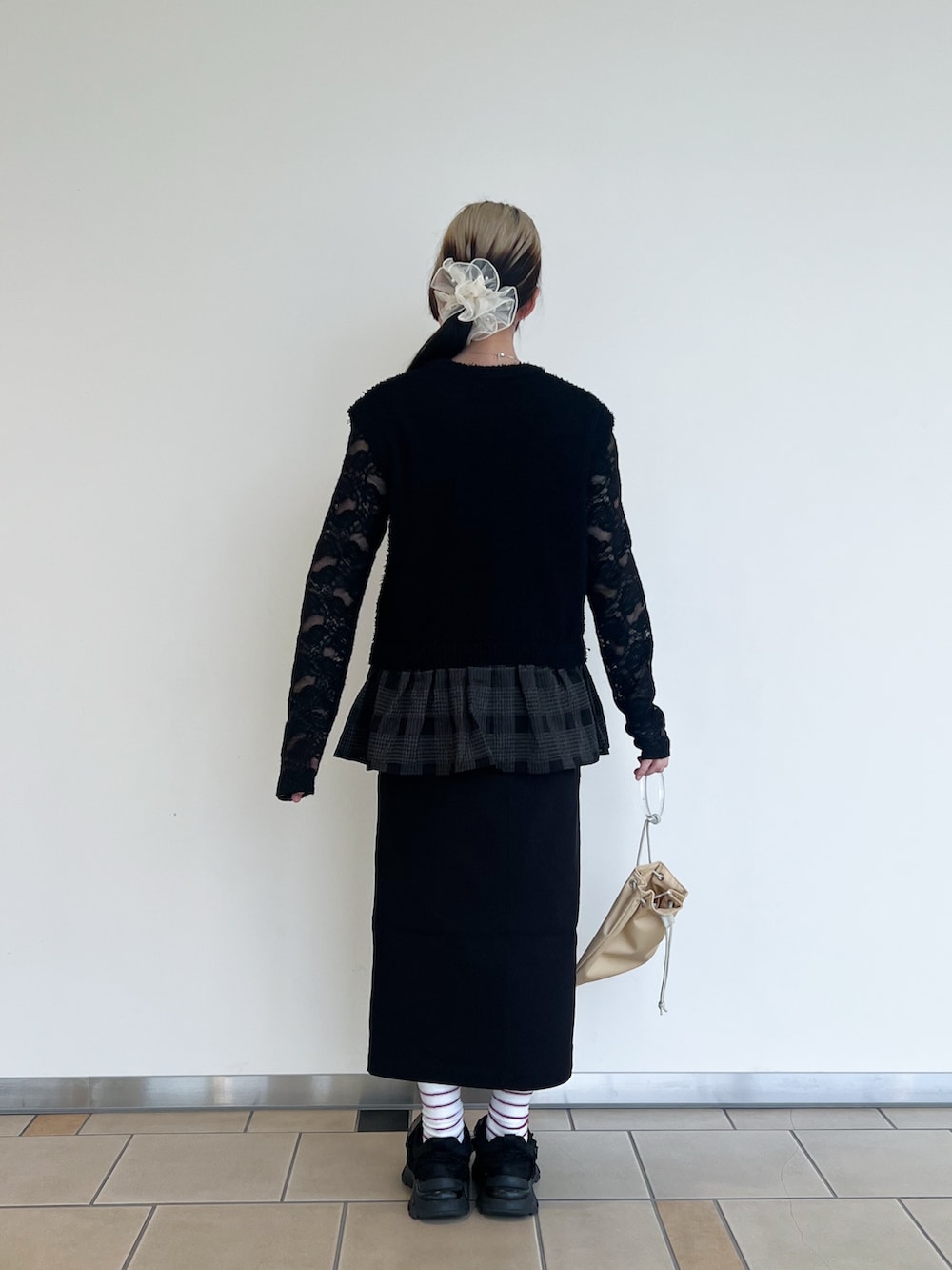 イエロー系のショルダーバッグ、ブラック系のスカート、ブラック系のTシャツ/カットソーを着用したレディースの秋コーディネートの3枚目の写真