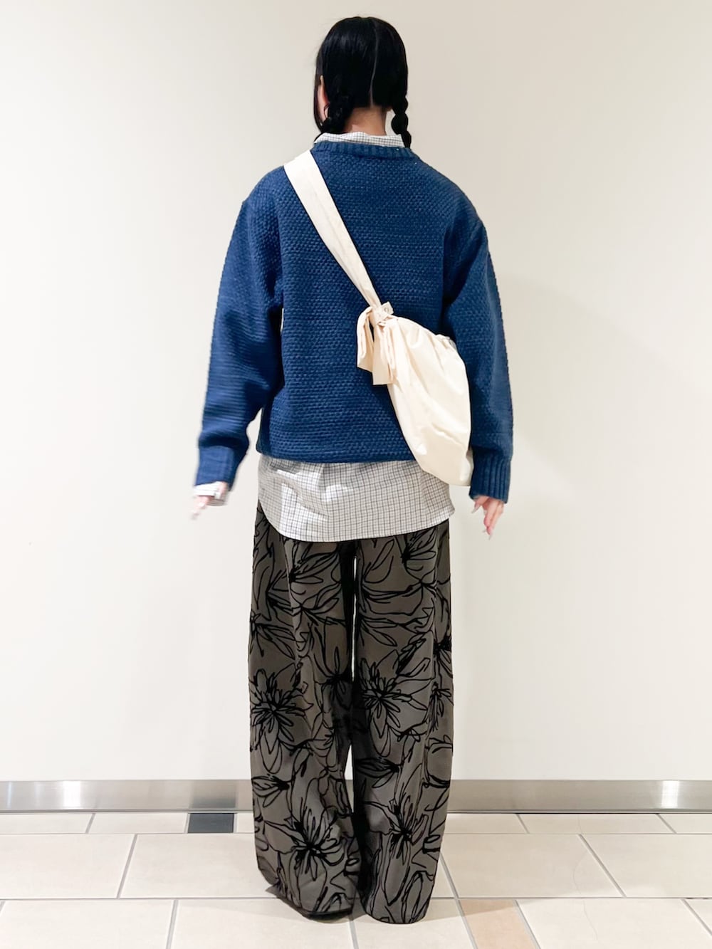 ブルー系のニット/セーター、ホワイト系のシャツ/ブラウス、ホワイト系のショルダーバッグを着用したレディースの冬コーディネートの2枚目の写真