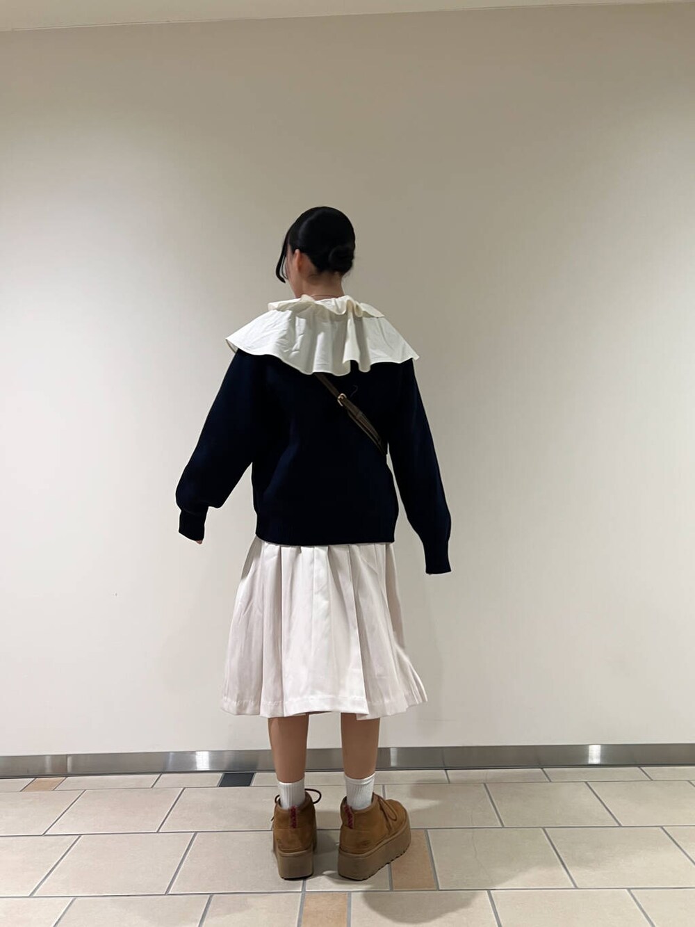 ベージュ系のハンドバッグ、グレー系のスカート、ホワイト系のシャツ/ブラウスを着用したレディースの冬コーディネートの3枚目の写真