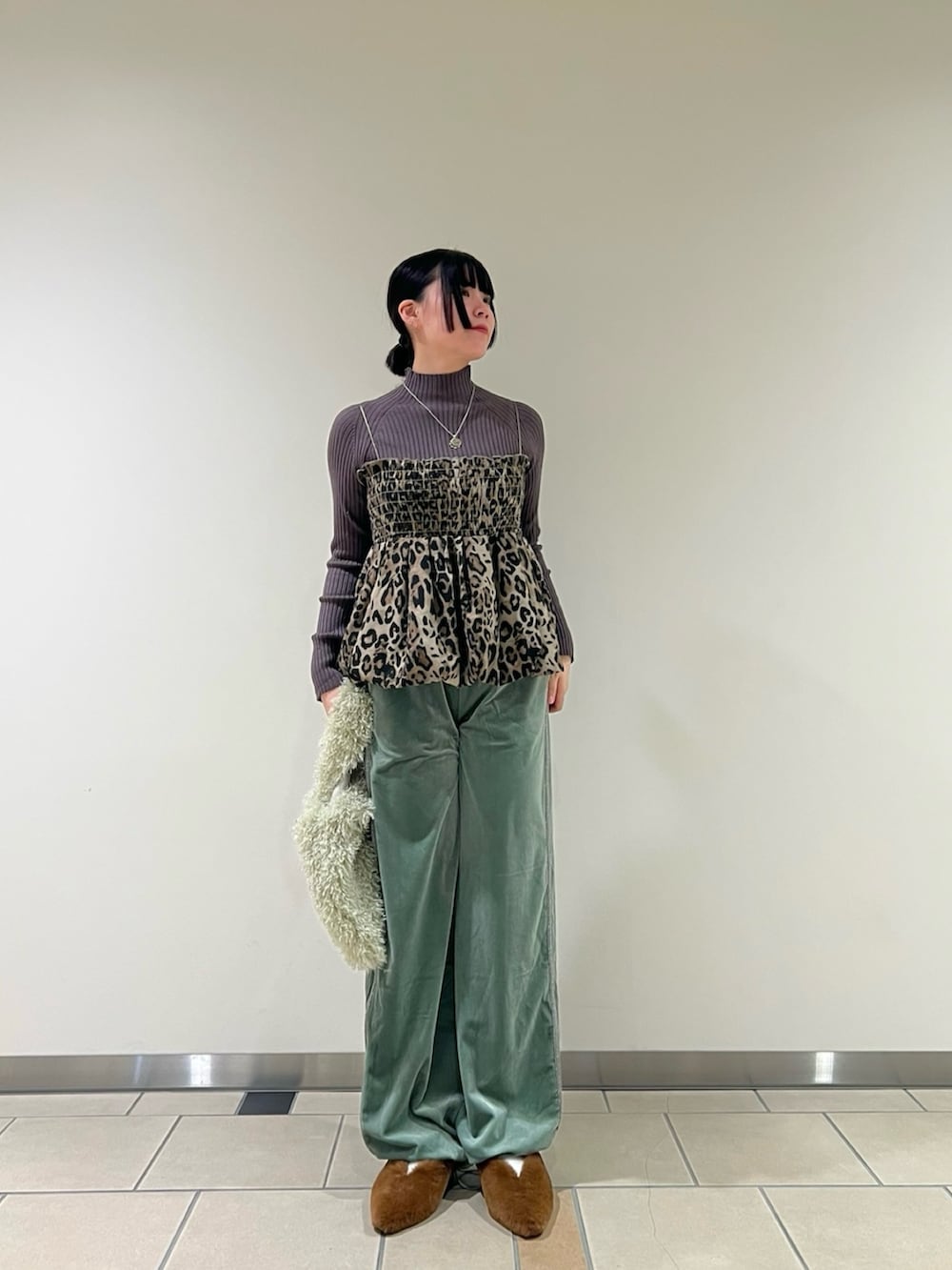 グレー系のニット/セーター、イエロー系のその他シューズ、グリーン系のその他パンツを着用したレディースの冬コーディネートの3枚目の写真