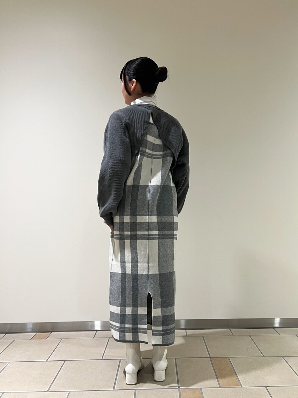 グレー系のワンピース、ホワイト系のハンドバッグ、ホワイト系のTシャツ/カットソーを着用したレディースの秋コーディネートの2枚目の写真