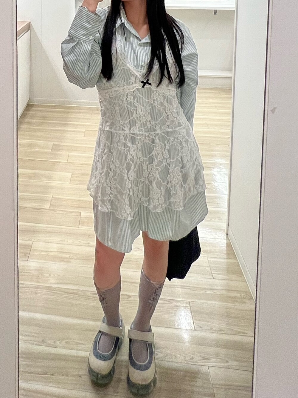 グリーン系のワンピースを着用したレディースの春コーディネートの2枚目の写真