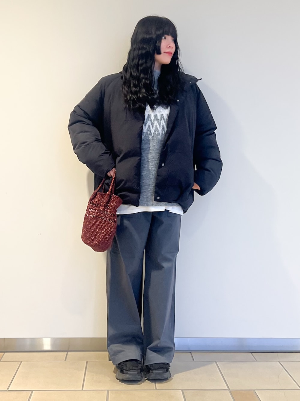 ホワイト系のTシャツ/カットソー、グレー系のニット/セーター、ブラック系のダウンジャケット/コートを着用したレディースの冬コーディネートの2枚目の写真