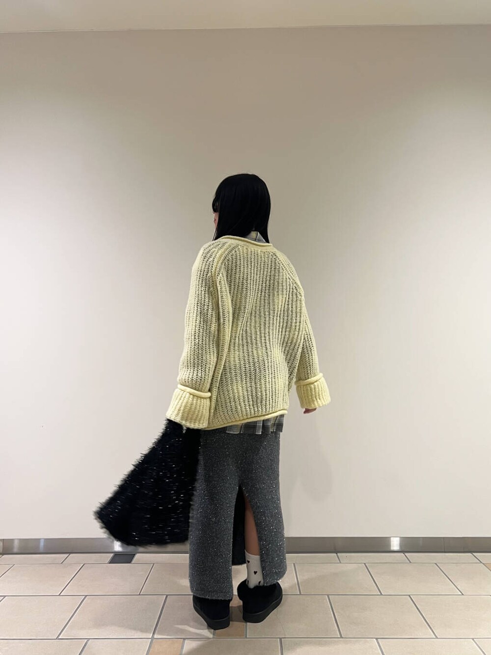 グレー系のスカート、ブラック系のトートバッグ、グレー系のシャツ/ブラウスを着用したレディースの冬コーディネートの2枚目の写真