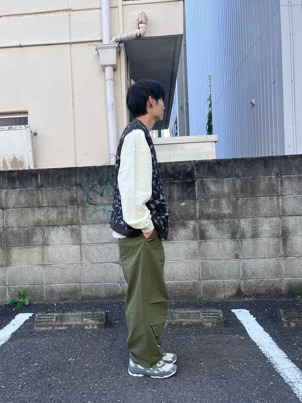 ブラック系のニット/セーター、ホワイト系のスウェット、グリーン系のその他パンツを着用したメンズの秋コーディネートの2枚目の写真