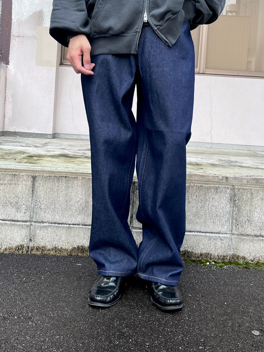 グレー系のパーカー、ブルー系のデニムパンツ、ブラック系のローファーを着用したメンズの秋コーディネートの4枚目の写真