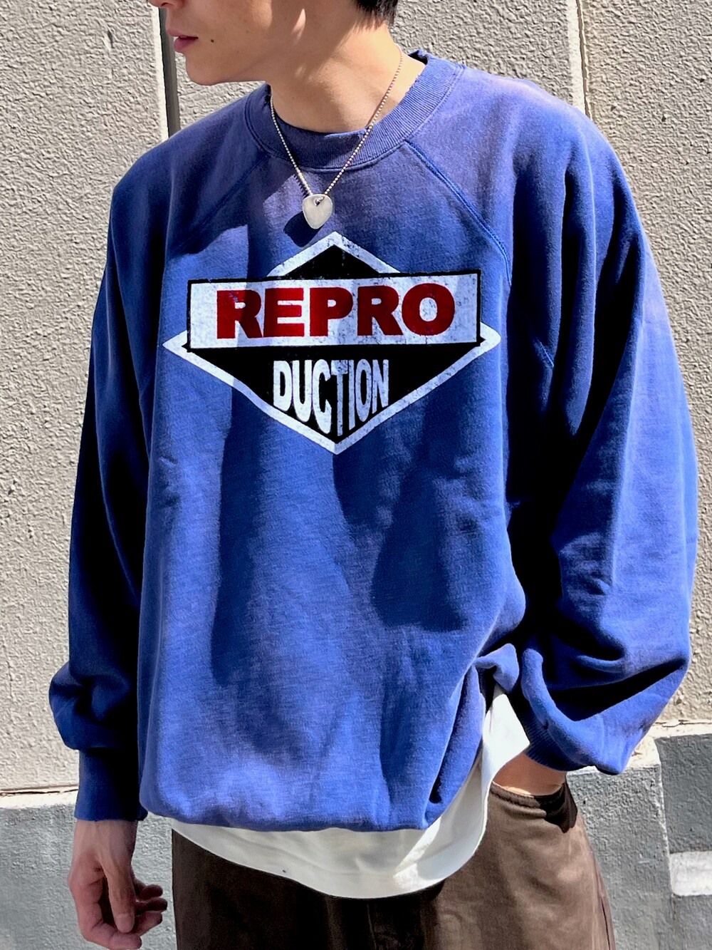 ブルー系のトップス、ブラウン系のデニムパンツを着用したメンズの秋コーディネートの2枚目の写真