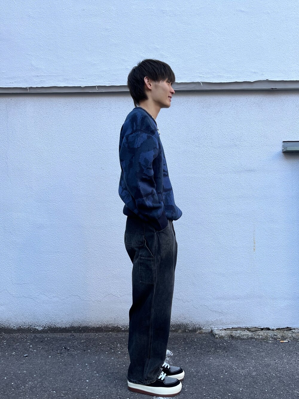 ブルー系のニット/セーター、ブラック系のその他パンツ、グレー系のスニーカーを着用したメンズの冬コーディネートの2枚目の写真