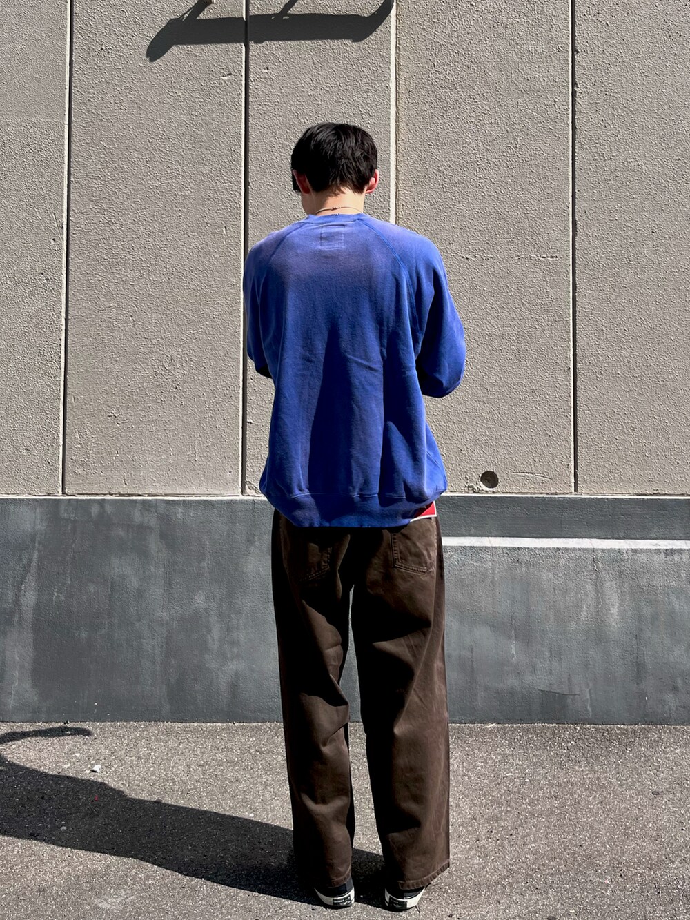 ブルー系のトップス、ブラウン系のデニムパンツを着用したメンズの秋コーディネートの3枚目の写真