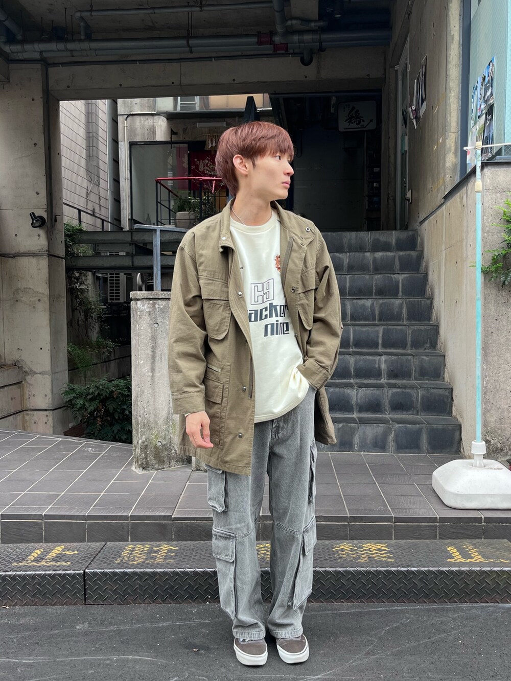 グリーン系のモッズコート、ブルー系のデニムパンツ、ホワイト系のTシャツ/カットソーを着用したメンズの秋コーディネートの2枚目の写真