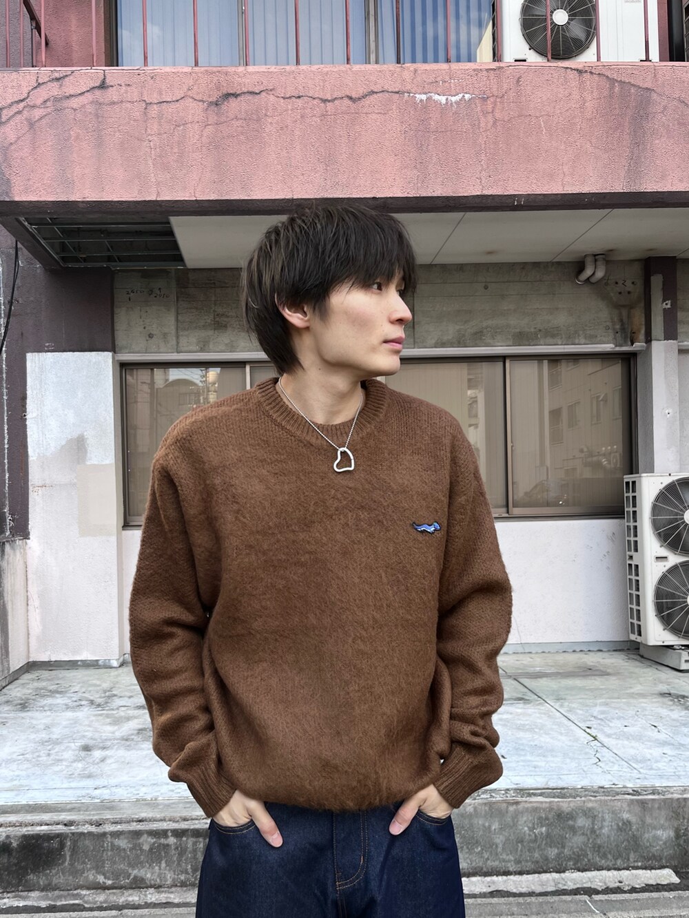 ブラウン系のニット/セーター、ブルー系のデニムパンツを着用したメンズの冬コーディネートの2枚目の写真