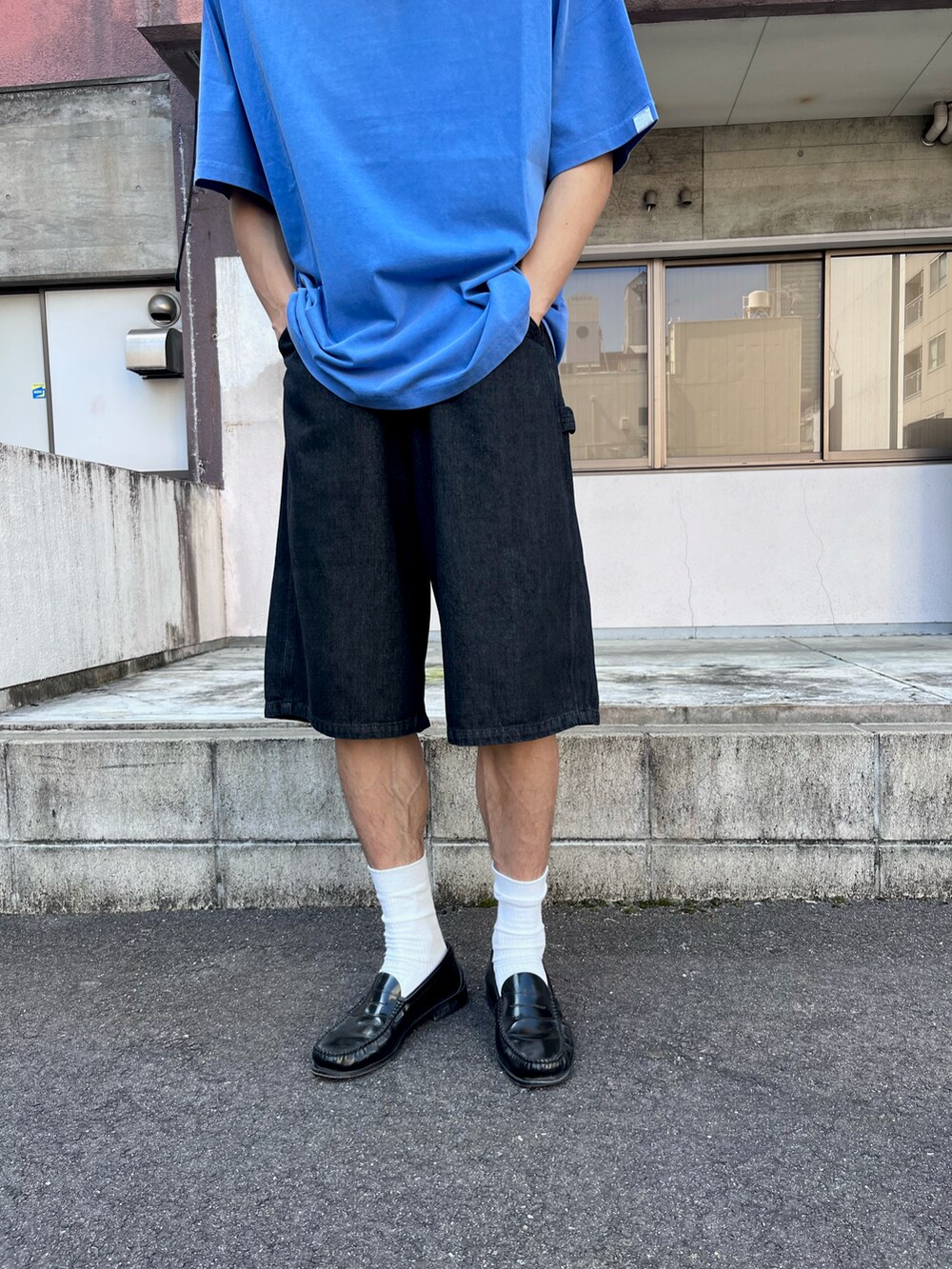 ブルー系のTシャツ/カットソー、ブラック系のデニムパンツ、ブラック系のローファーを着用したメンズの秋コーディネートの5枚目の写真