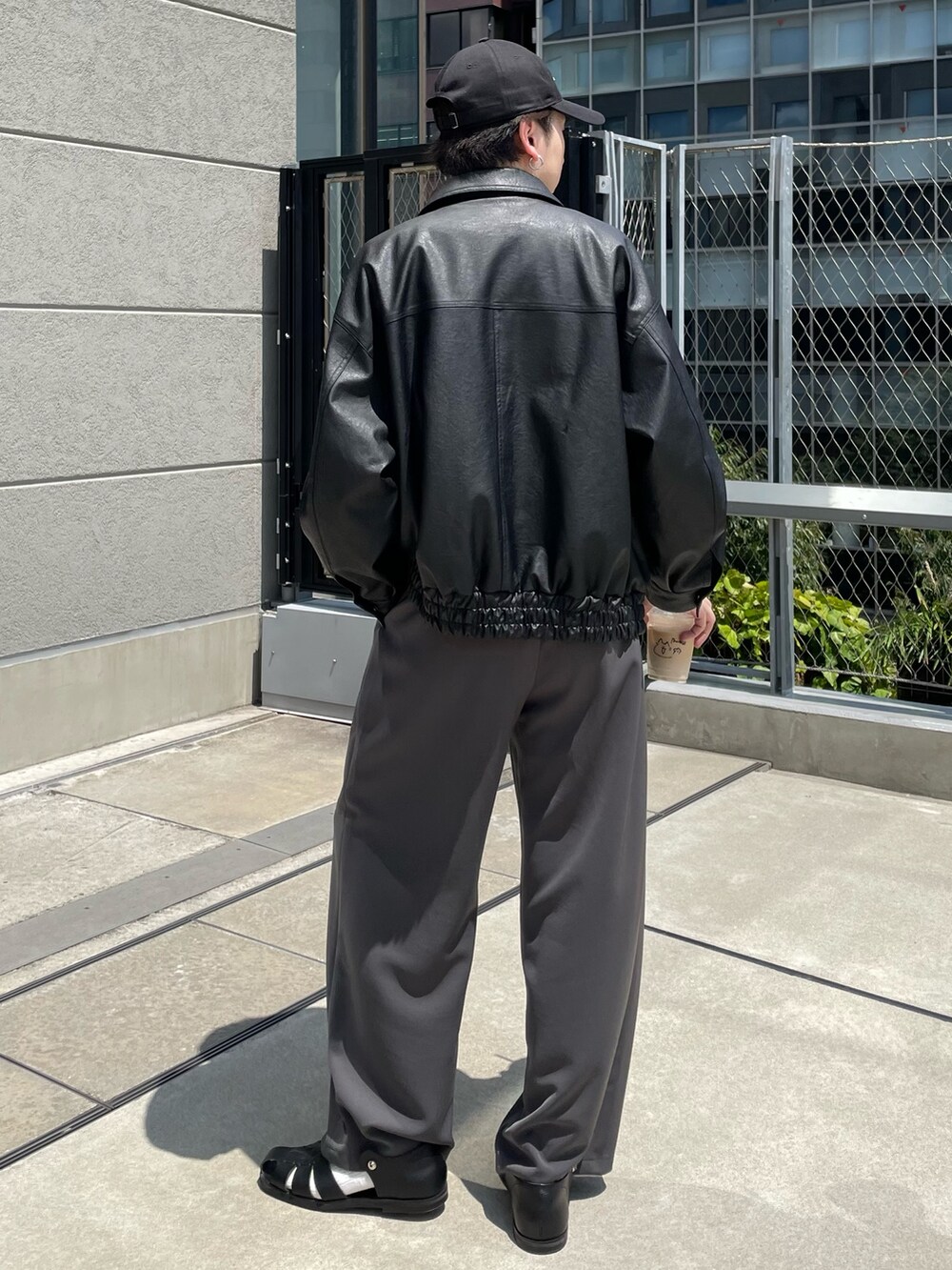 ブラック系のブルゾン、グレー系のその他パンツ、ブラック系のキャップを着用したメンズの夏コーディネートの3枚目の写真