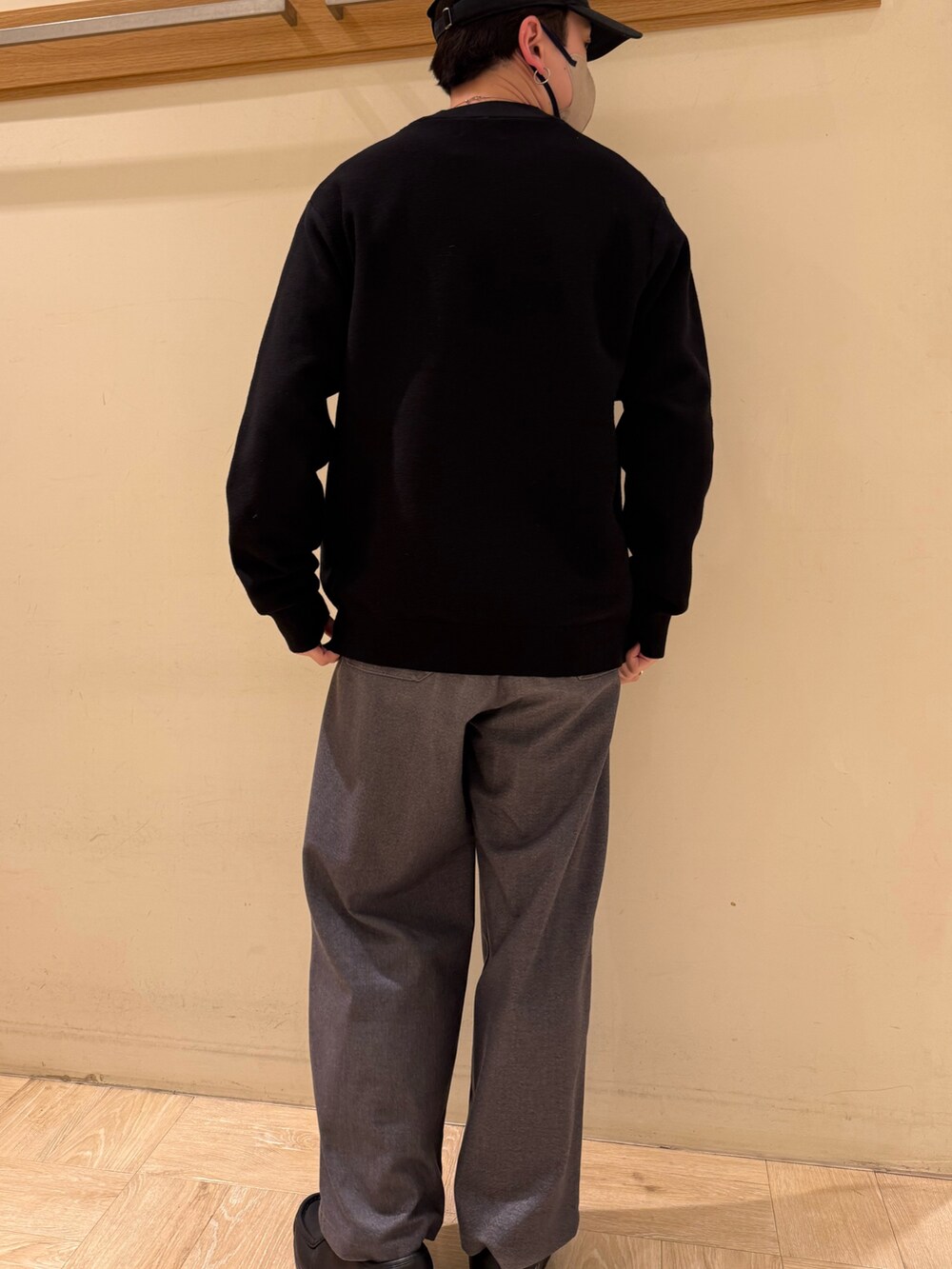 ブラック系のニット/セーター、グレー系のスラックスを着用したメンズの冬コーディネートの5枚目の写真