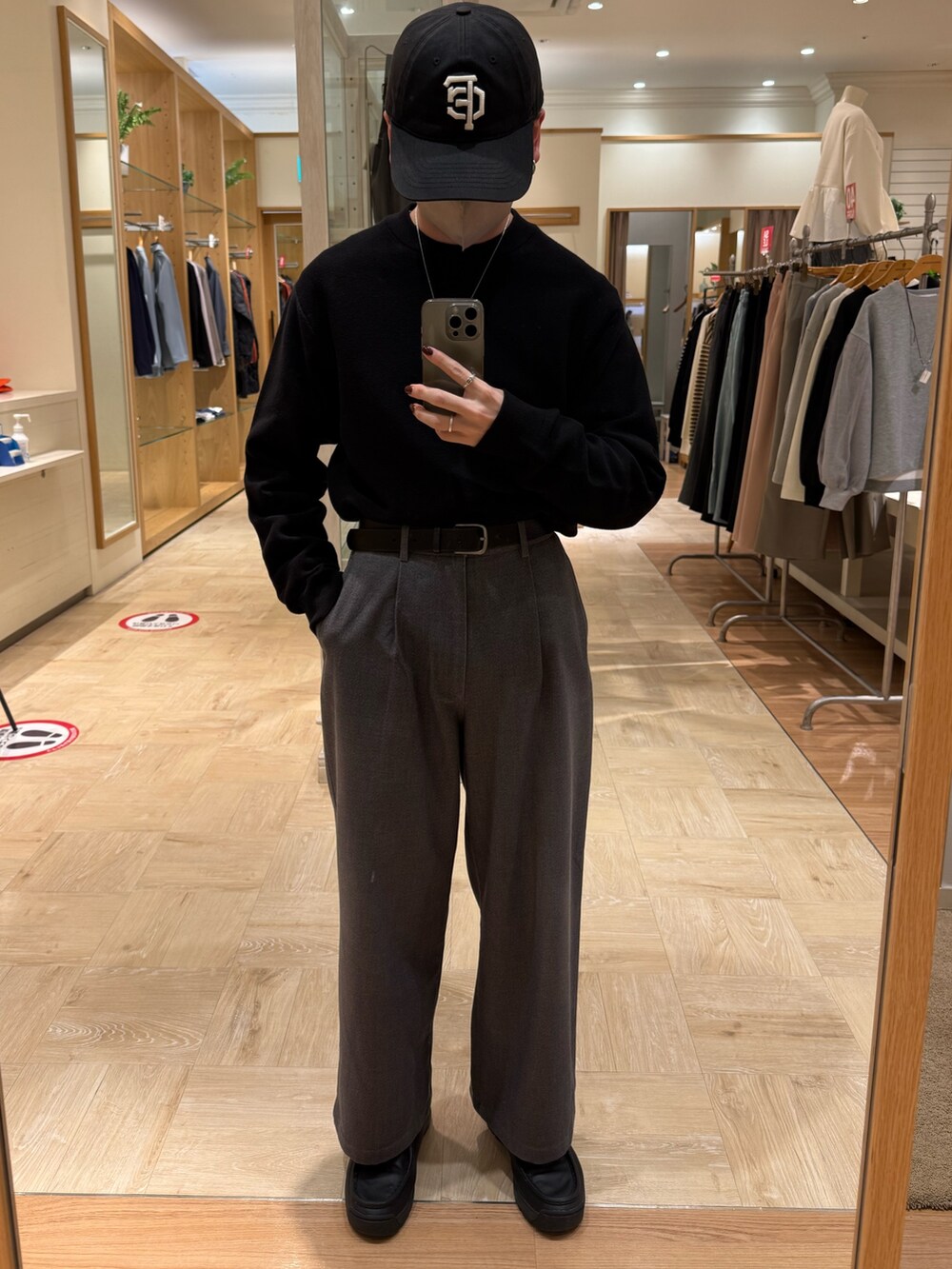 ブラック系のニット/セーター、グレー系のスラックスを着用したメンズの冬コーディネートの6枚目の写真