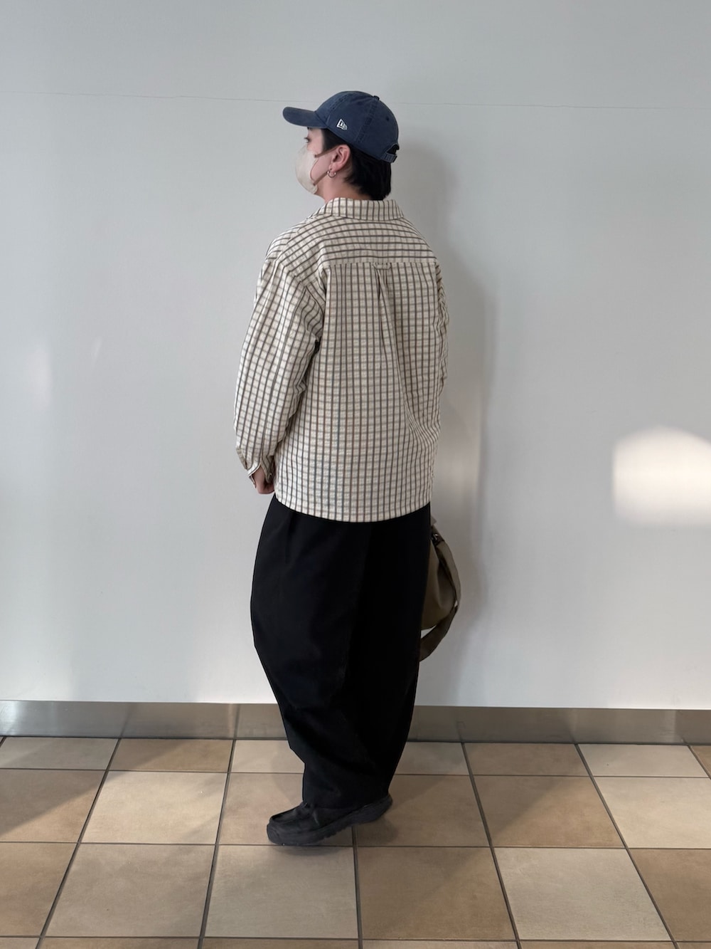 ホワイト系のブルゾン、ベージュ系のショルダーバッグ、ブラック系のその他パンツを着用したメンズの春コーディネートの3枚目の写真