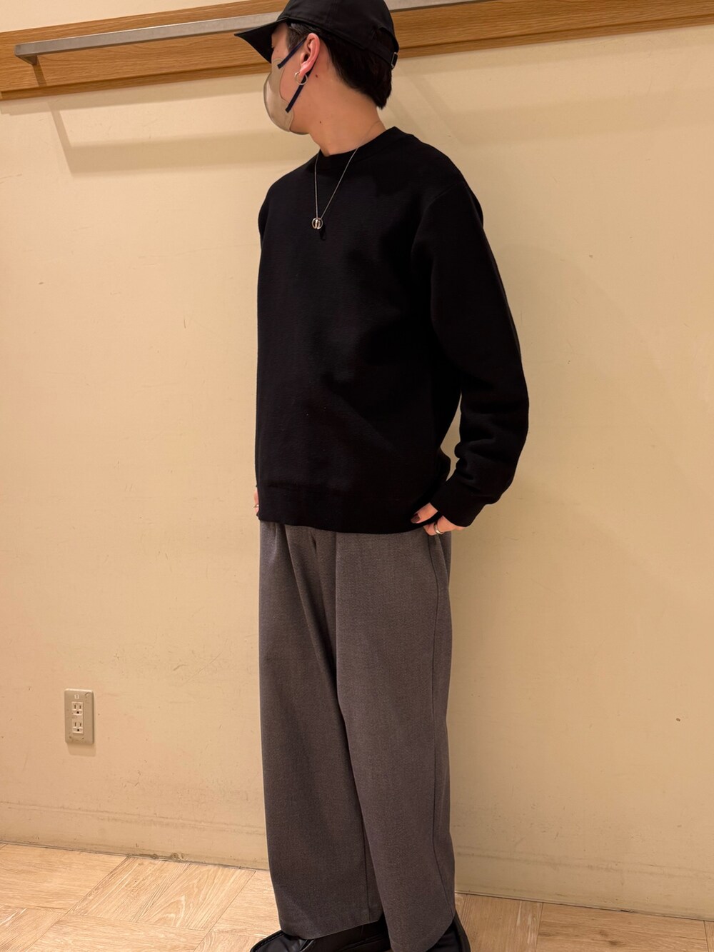 ブラック系のニット/セーター、グレー系のスラックスを着用したメンズの冬コーディネートの3枚目の写真