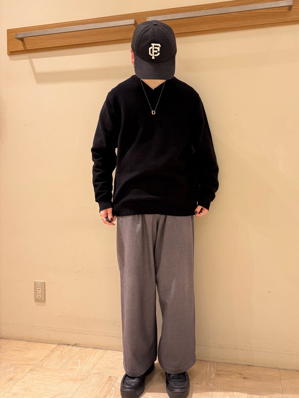 ブラック系のニット/セーター、グレー系のスラックスを着用したメンズの冬コーディネートの2枚目の写真