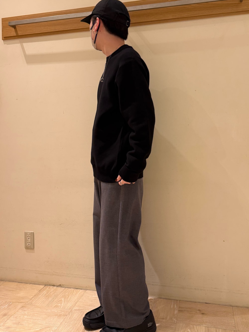 ブラック系のニット/セーター、グレー系のスラックスを着用したメンズの冬コーディネートの4枚目の写真