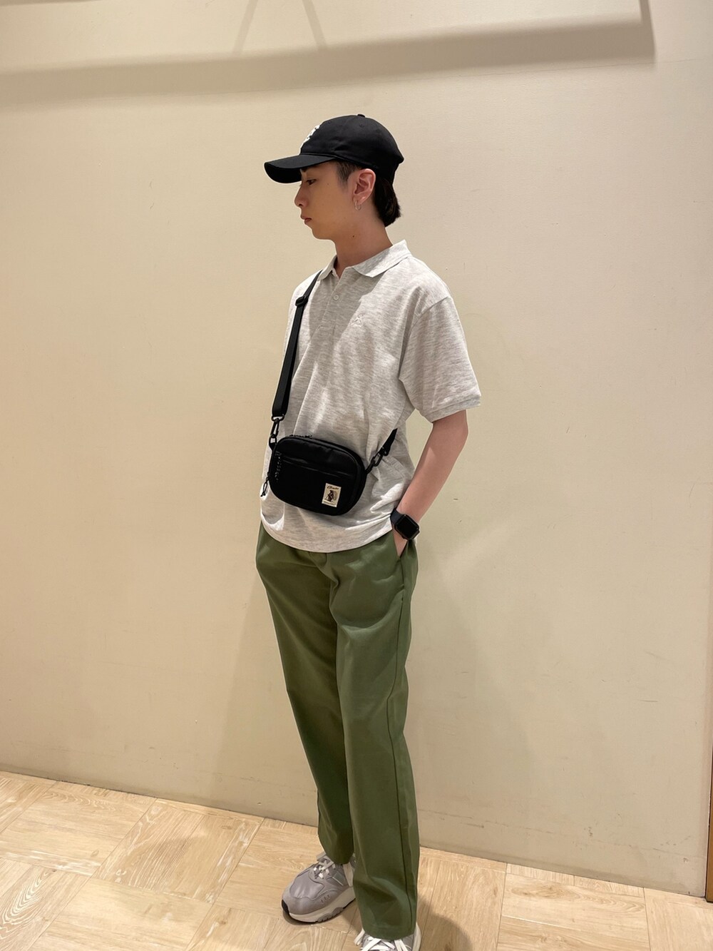 グレー系のポロシャツ、グリーン系のその他パンツ、ブラック系のキャップを着用したメンズの夏コーディネートの3枚目の写真