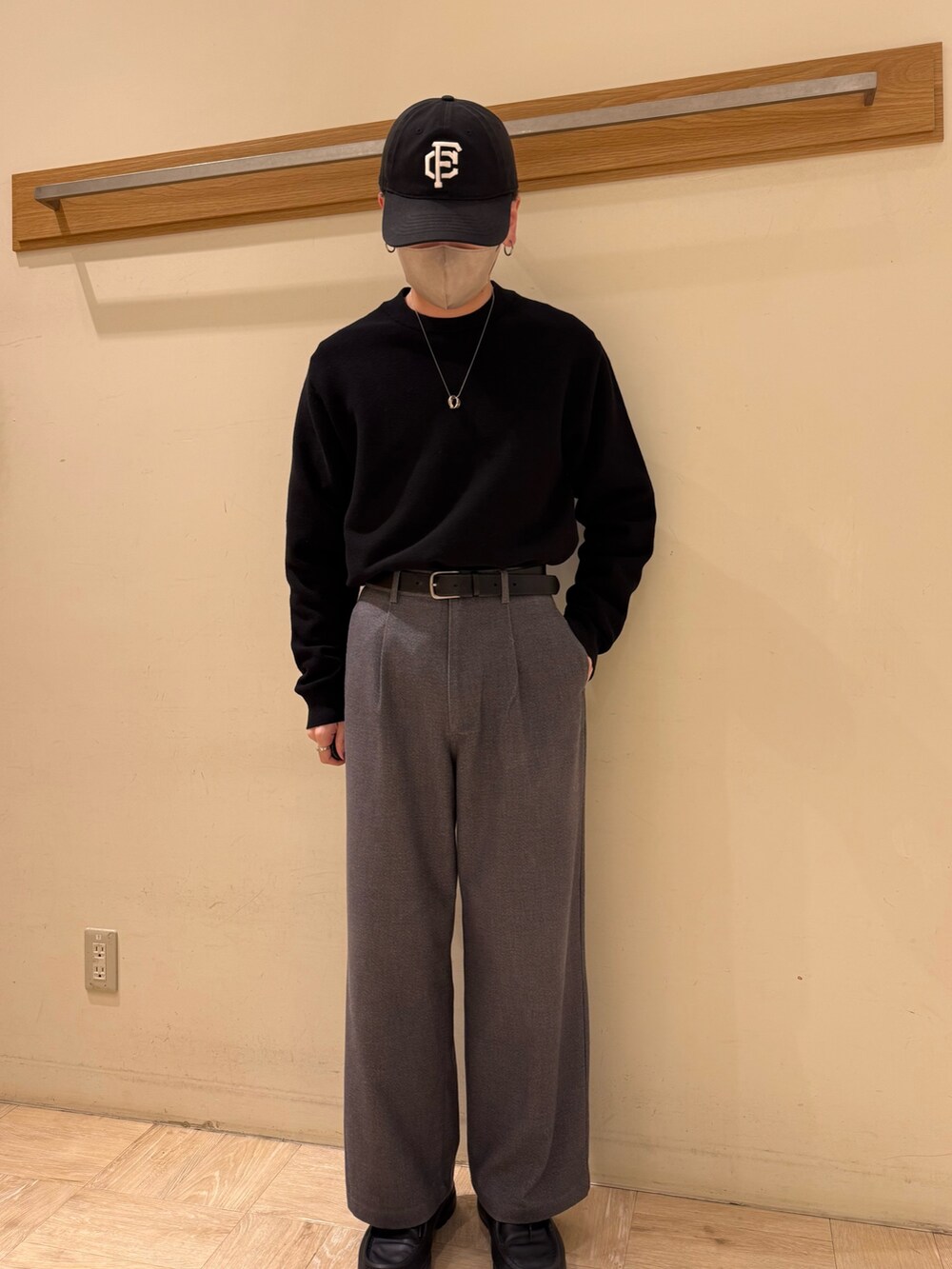 ブラック系のニット/セーター、グレー系のスラックスを着用したメンズの冬コーディネートの7枚目の写真