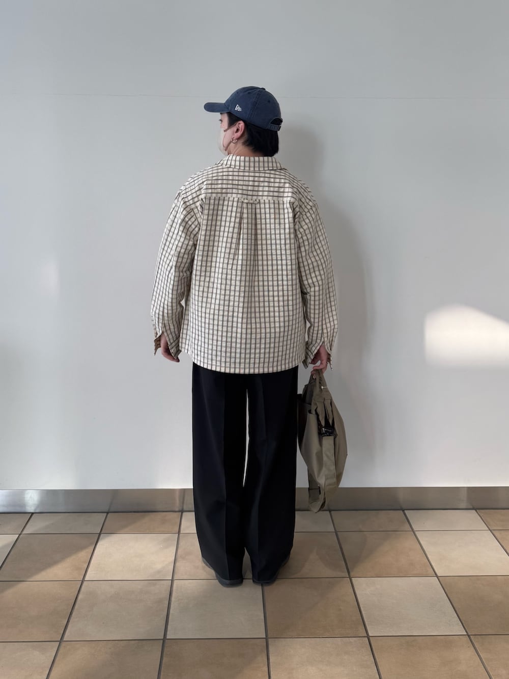 ホワイト系のブルゾン、ベージュ系のショルダーバッグ、ブラック系のその他パンツを着用したメンズの春コーディネートの4枚目の写真