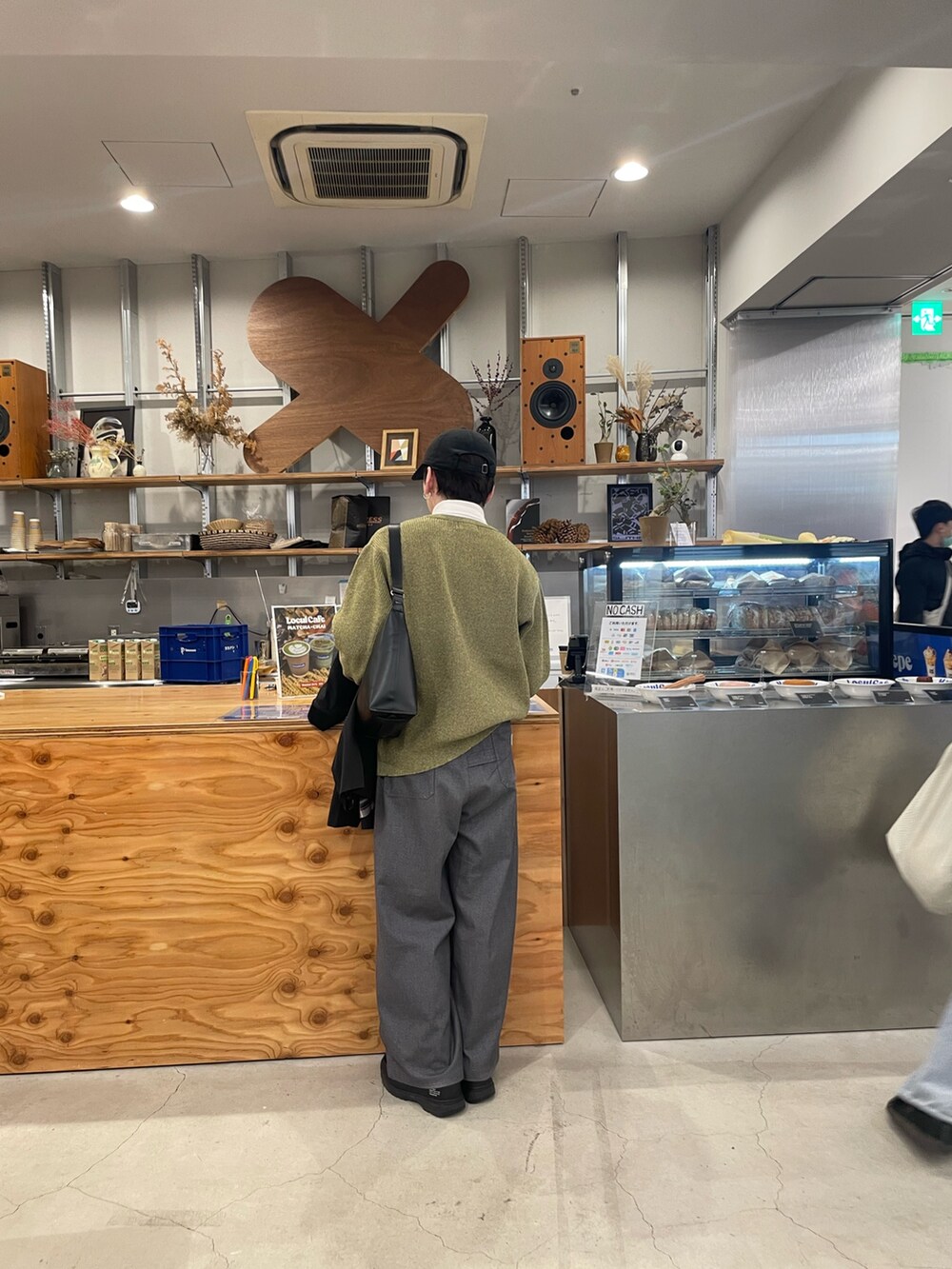 グレー系のスラックス、イエロー系のニット/セーター、ブラック系のブルゾンを着用したメンズの冬コーディネートの4枚目の写真