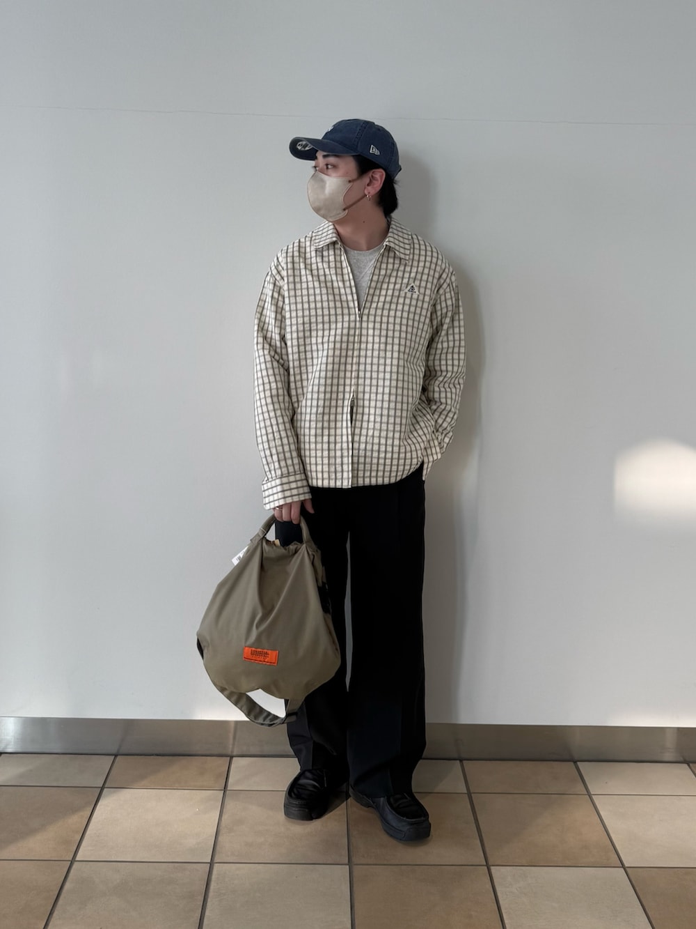 ホワイト系のブルゾン、ベージュ系のショルダーバッグ、ブラック系のその他パンツを着用したメンズの春コーディネートの5枚目の写真