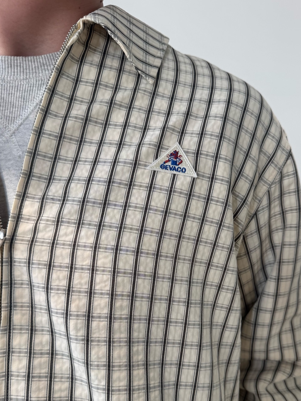 ホワイト系のブルゾン、ベージュ系のショルダーバッグ、ブラック系のその他パンツを着用したメンズの春コーディネートの7枚目の写真