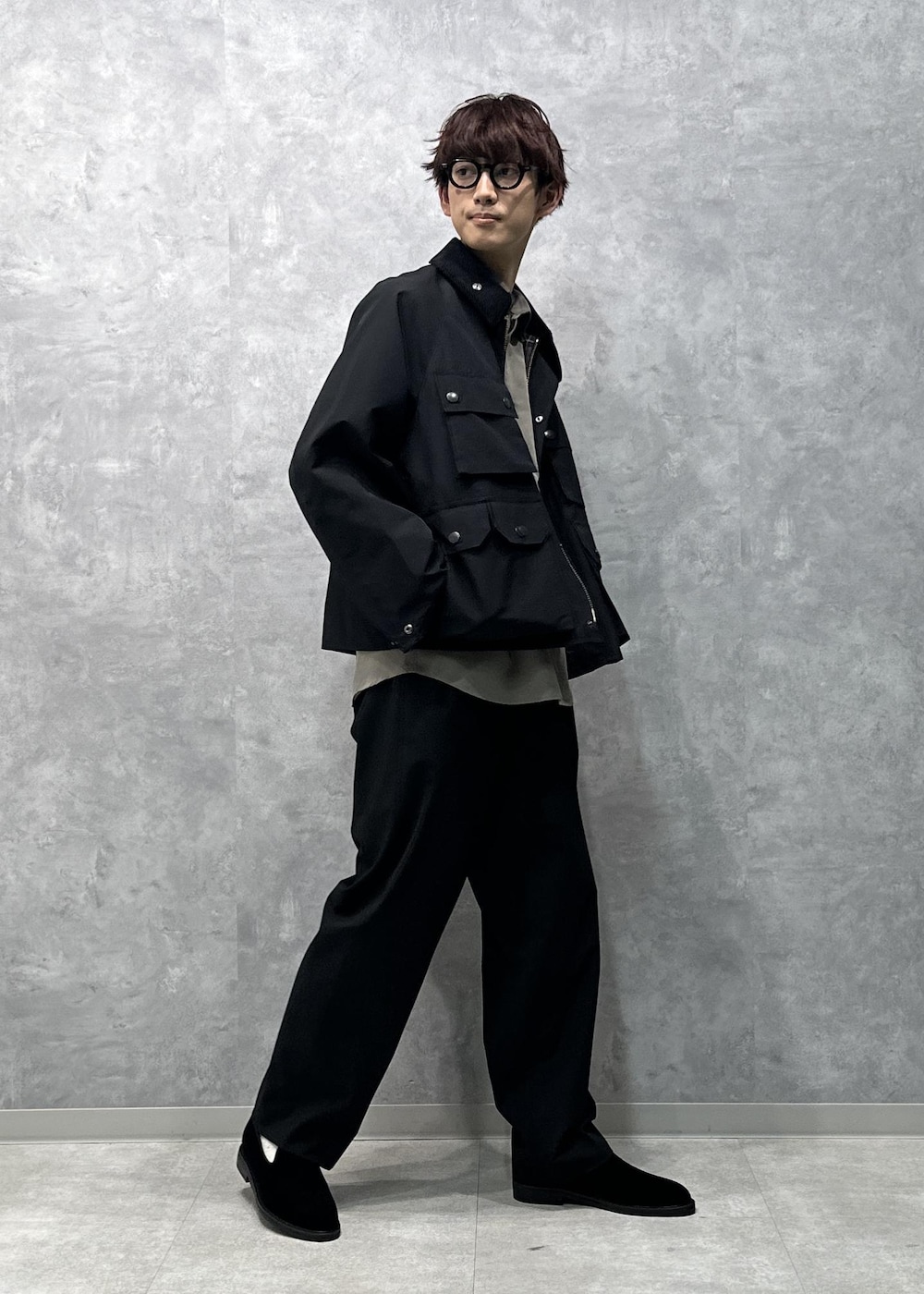 グリーン系のシャツ/ブラウス、ブラック系のスラックス、ブラック系のスリッポンを着用したメンズの秋コーディネートの2枚目の写真