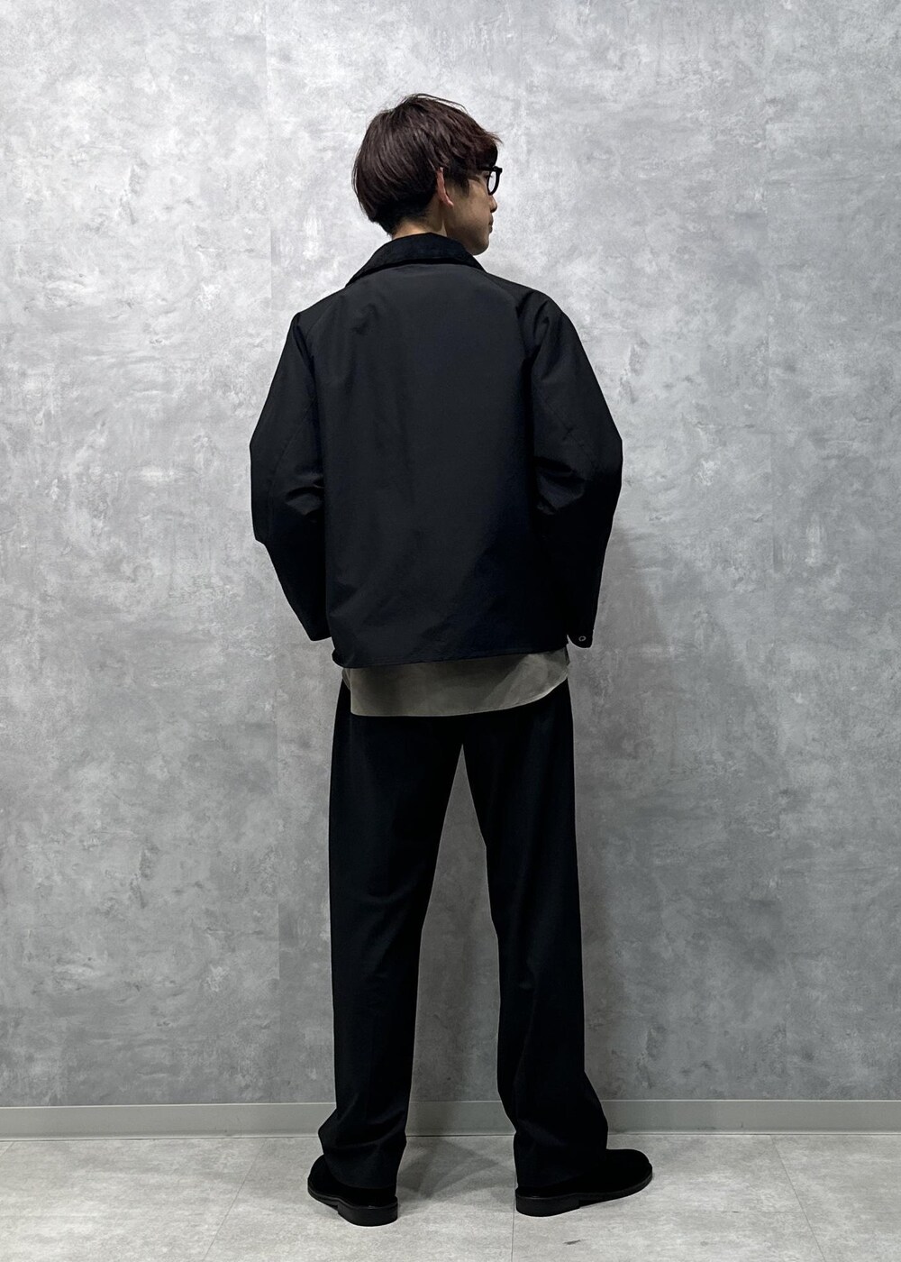 グリーン系のシャツ/ブラウス、ブラック系のスラックス、ブラック系のスリッポンを着用したメンズの秋コーディネートの4枚目の写真